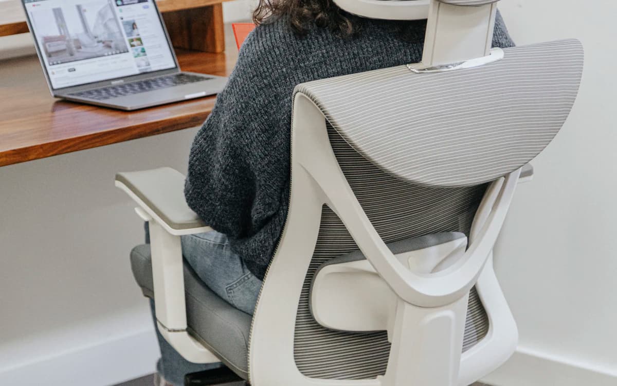 Pekerja kantoran memegangi leher yang pegal setelah duduk lama di depan laptop
